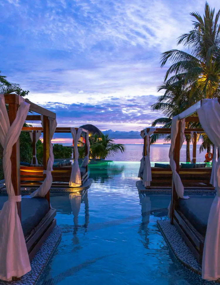 Hotel pool area with lounge chairs and tropical atmosphere