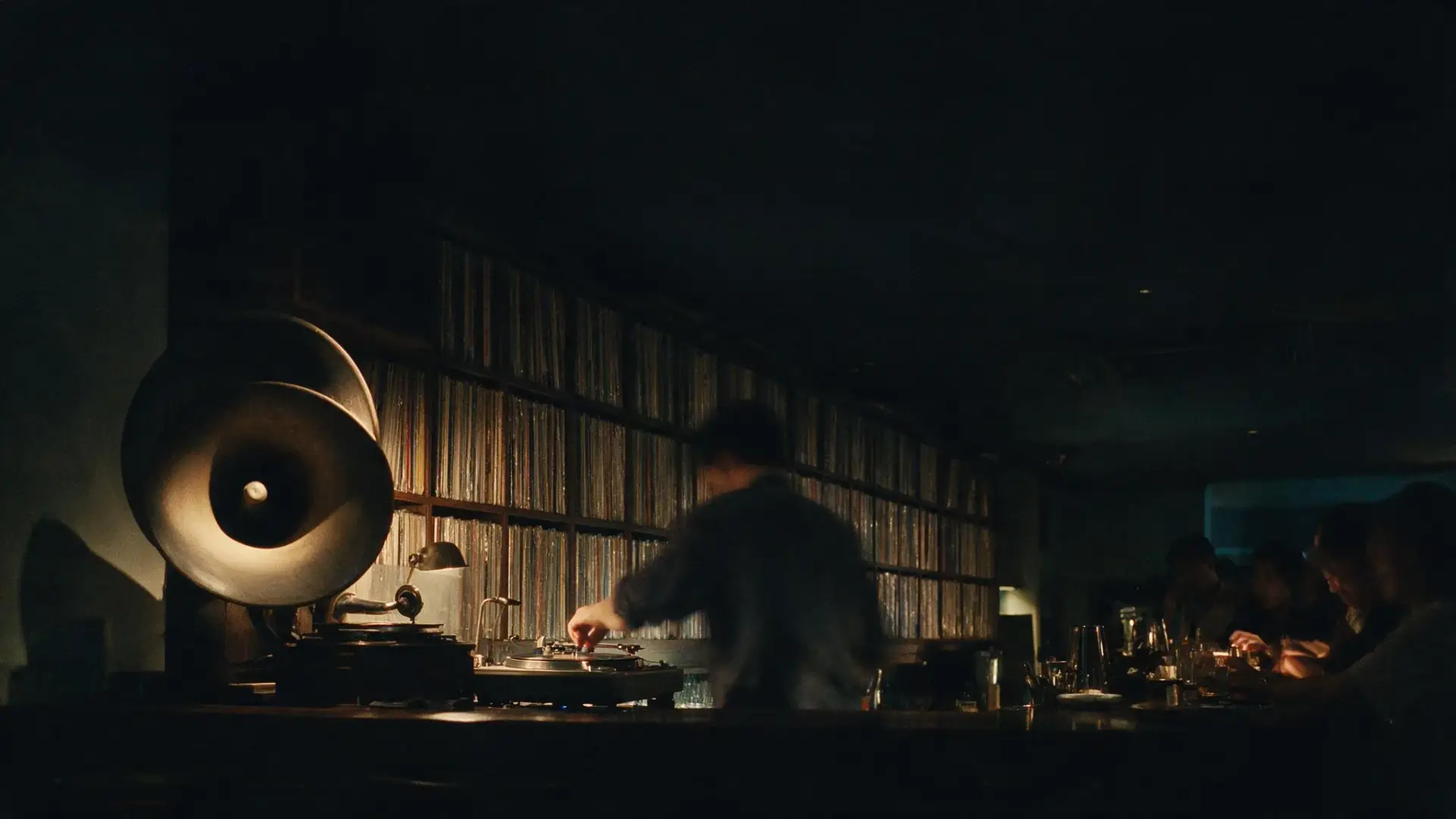 A listening bar in Bangkok at night, a bartender lowering the needle onto a record.